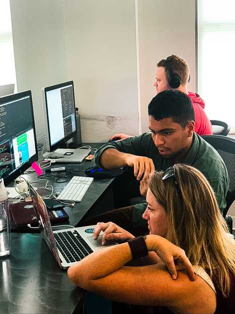 Students collaborating in front of laptop